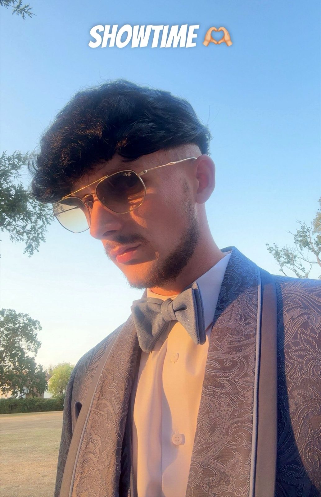 Jake Essex outdoors at golden hour in a paisley dinner jacket